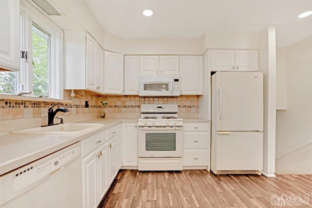63 South Cliff Road Colonia, NJ 07067 - Photo 9 of 37 a kitchen with a refrigerator sink and cabinets