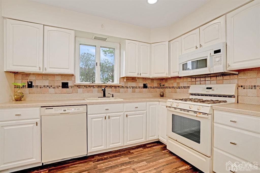 63 South Cliff Road Colonia, NJ 07067 - Photo 10 of 37 a kitchen with cabinets appliances a sink and a window