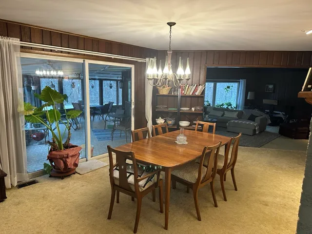 a dining room with furniture a chandelier and window