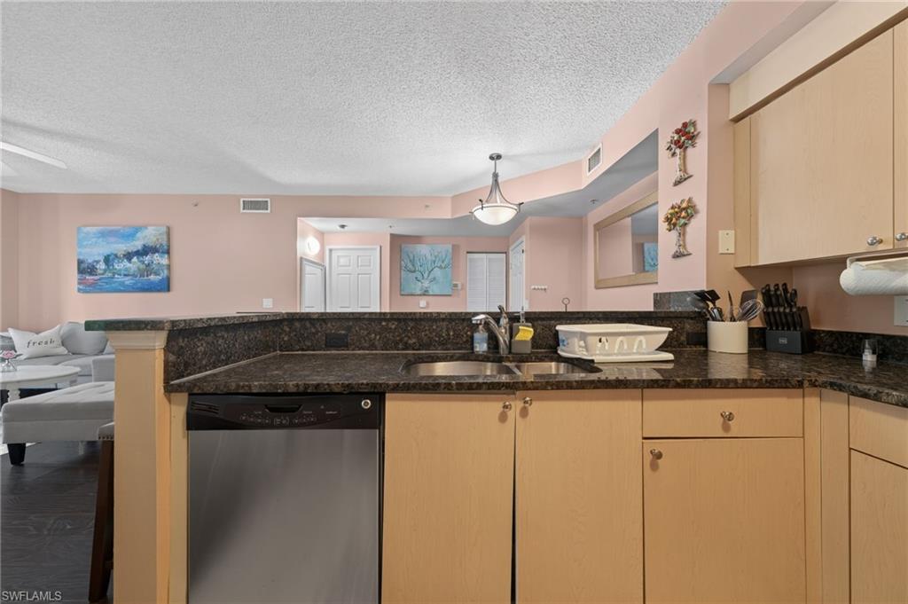 1105 Reserve Court, Unit 206 Naples, FL 34105 - Photo 6 of 23 a kitchen with granite countertop a sink and cabinets