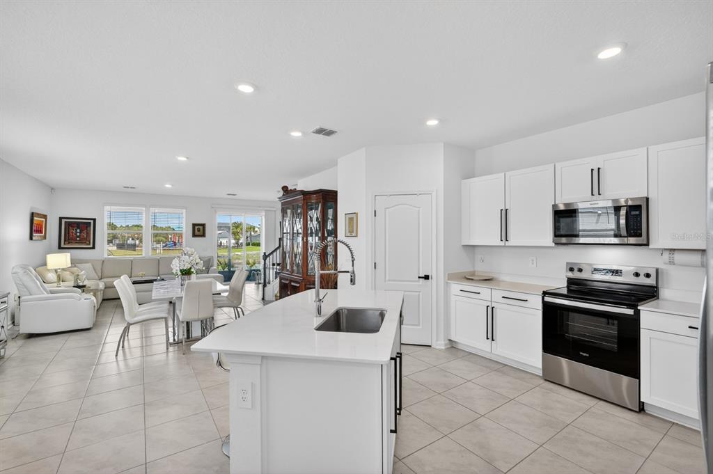 336 Redbud Road Palm Coast, FL 32137 - Photo 2 of 40 a kitchen with stainless steel appliances kitchen island granite countertop a sink and cabinets