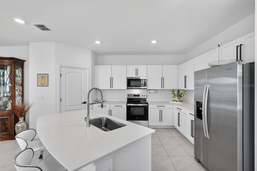 336 Redbud Road Palm Coast, FL 32137 - Photo 24 of 40 a kitchen with a refrigerator a sink a stove and cabinets