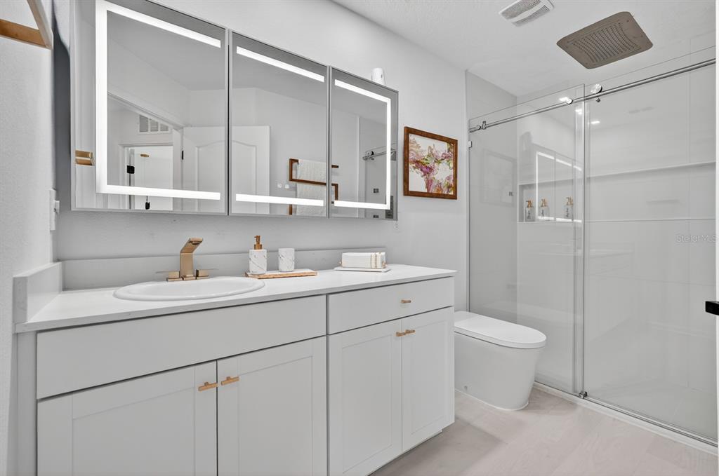 336 Redbud Road Palm Coast, FL 32137 - Photo 28 of 40 a bathroom with a toilet a sink a mirror and a shower