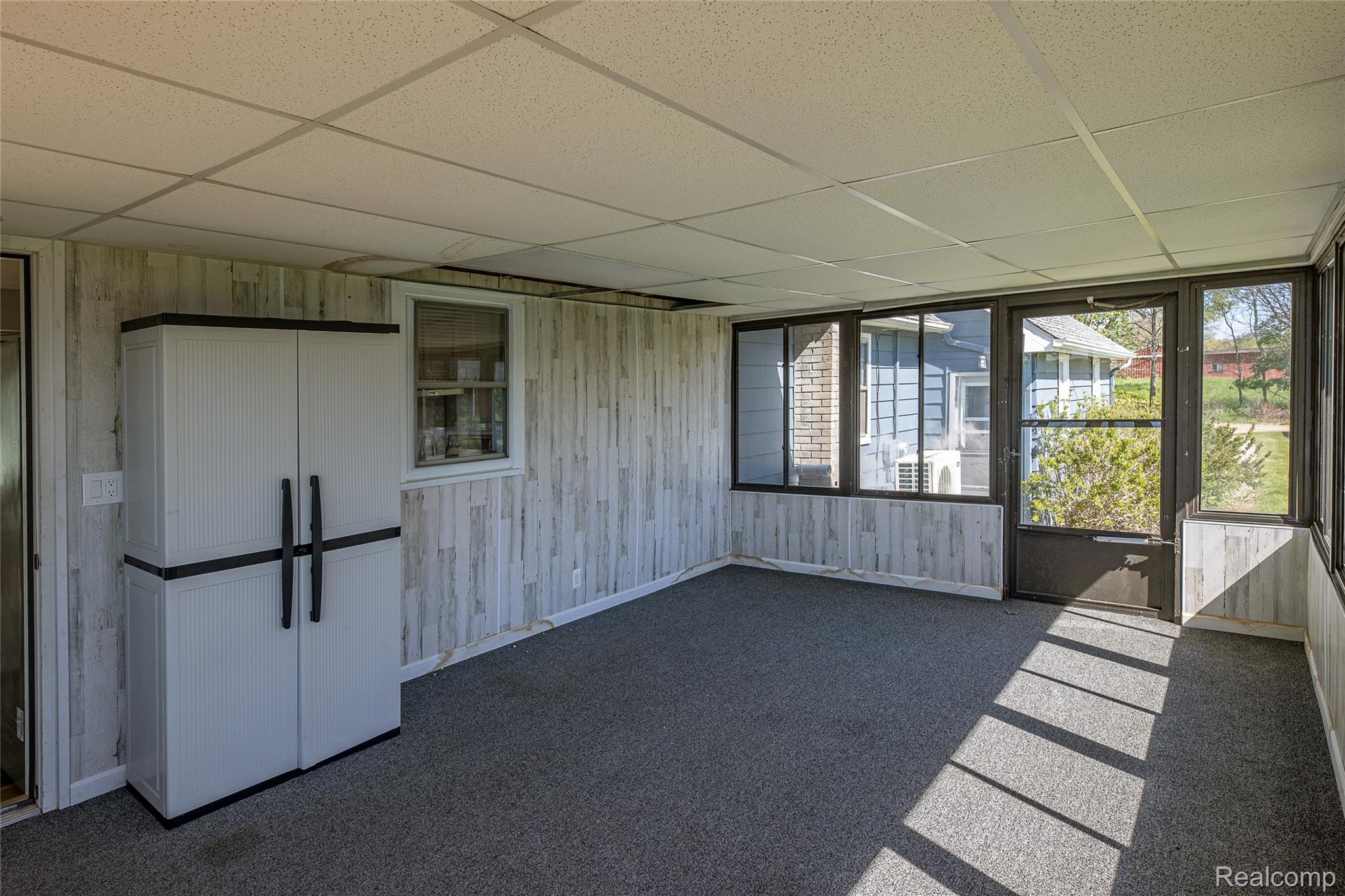 2855 Farmers Creek Road Metamora, MI 48455 - Photo 25 of 51 Sunroom featuring grey carpeting, drop ceiling, and wood-finish paneling