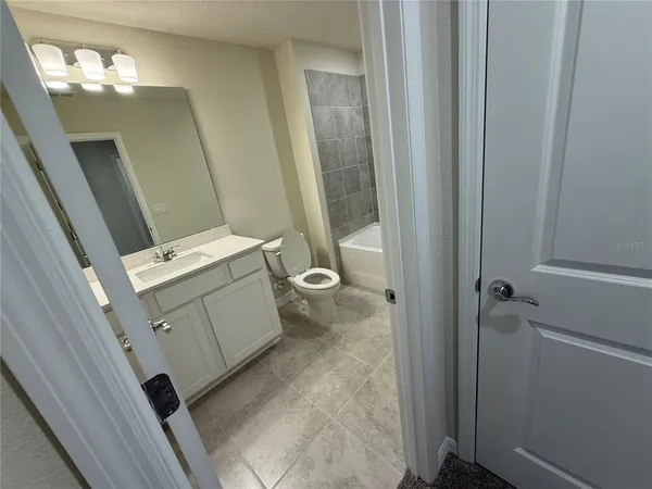 a white toilet sitting next to a bath tub