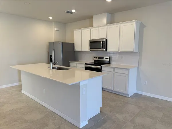 a kitchen with stainless steel appliances a stove a sink a microwave and cabinets