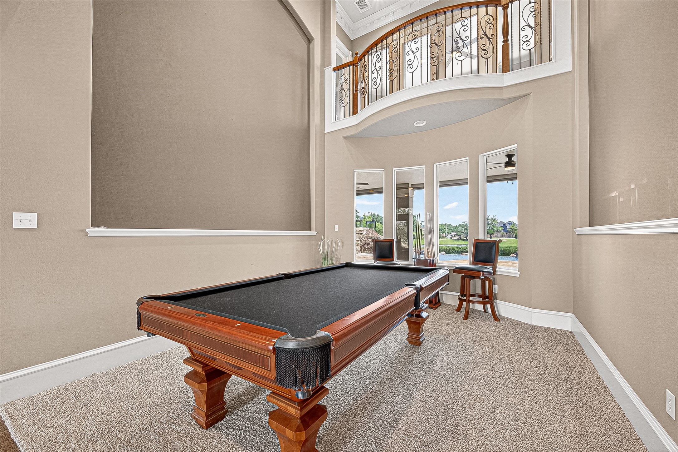 25626 Windy Isle Court Spring, TX 77389 - Photo 10 of 45 This stylish formal living room or billiard room features high ceilings, elegant railings on an upper loft area, and large windows offering scenic views of the back yard and water features.