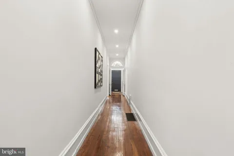 a view of a hallway with wooden floor