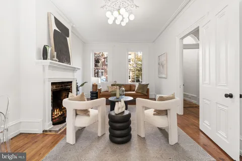 a living room with furniture a fireplace and a chandelier