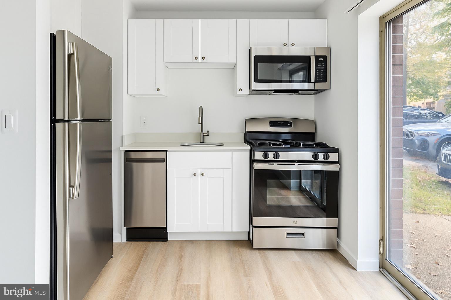 4465 MacArthur Boulevard Northwest, Unit 8 Washington, DC 20007 - Photo 1 of 6 a kitchen with stainless steel appliances a stove a microwave and a refrigerator