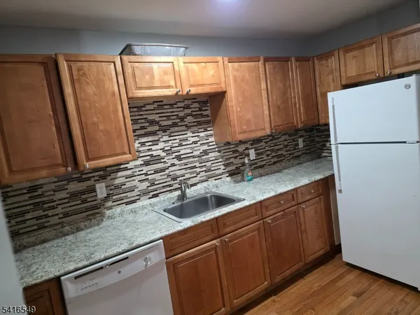 a kitchen with stainless steel appliances granite countertop a sink a refrigerator and a microwave