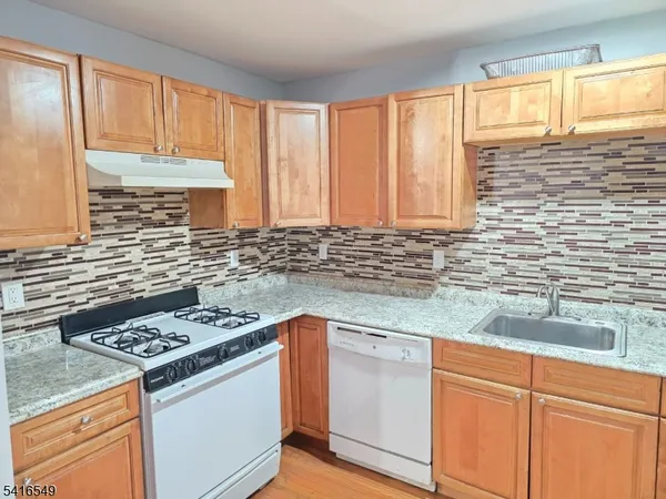 a kitchen with granite countertop cabinets stainless steel appliances a sink and a window