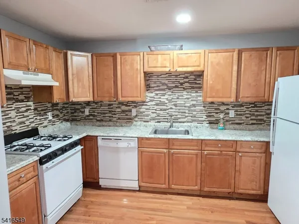 a kitchen with stainless steel appliances kitchen island wooden cabinets a sink and a window