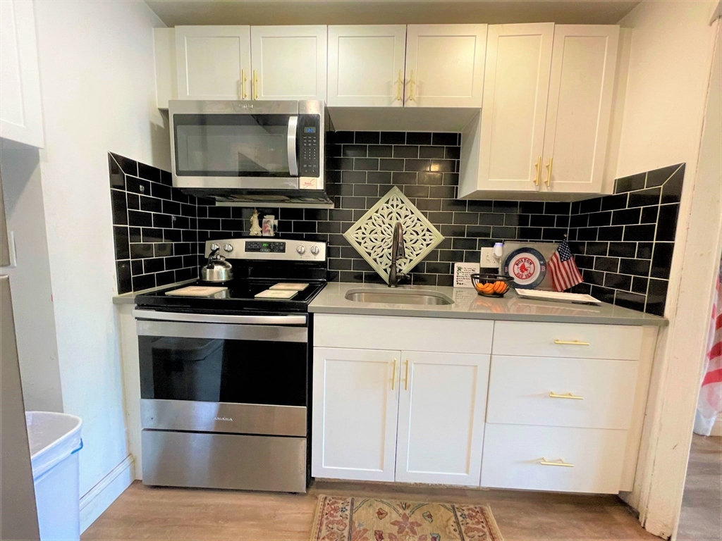 a kitchen with microwave cabinets and a stove top oven