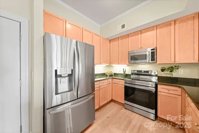 a kitchen with granite countertop stainless steel appliances a refrigerator cabinets and microwave