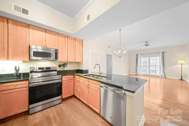a kitchen with stainless steel appliances granite countertop a stove sink and microwave