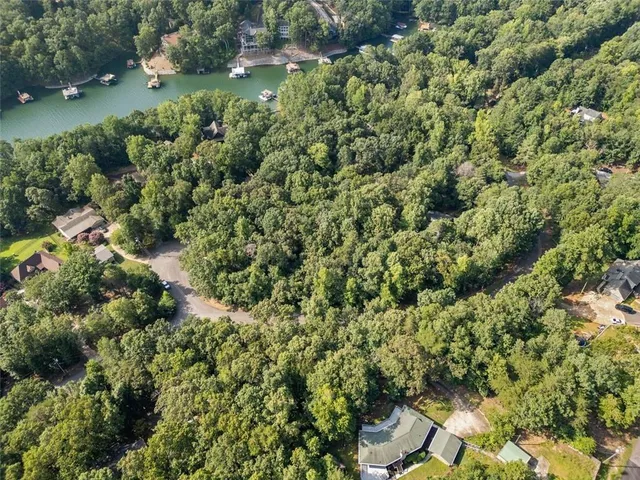 an aerial view of residential house with outdoor space and trees all around