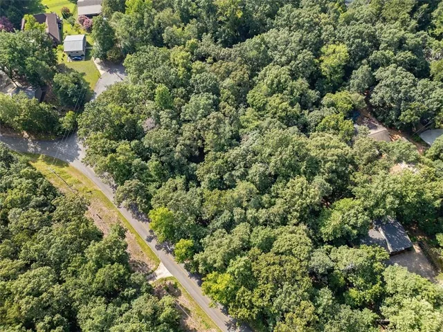 an aerial view of residential house with outdoor space and trees all around
