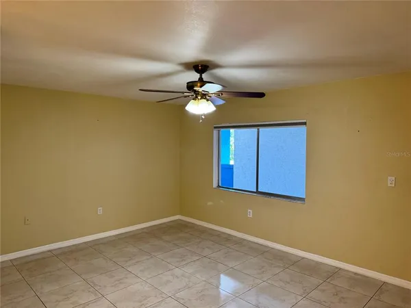 a view of a livingroom with a chandelier fan and windows