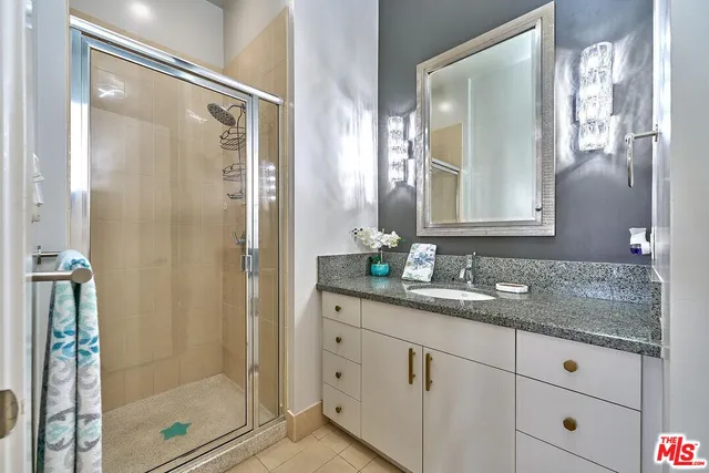 a bathroom with a granite countertop sink mirror and shower