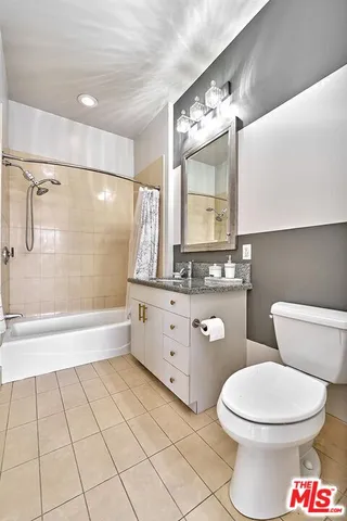 a bathroom with a toilet a sink a mirror a vanity and bathtub