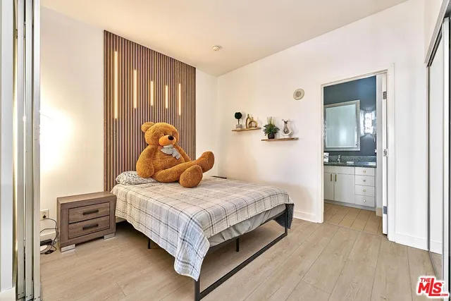 a bedroom with a bed and a refrigerator