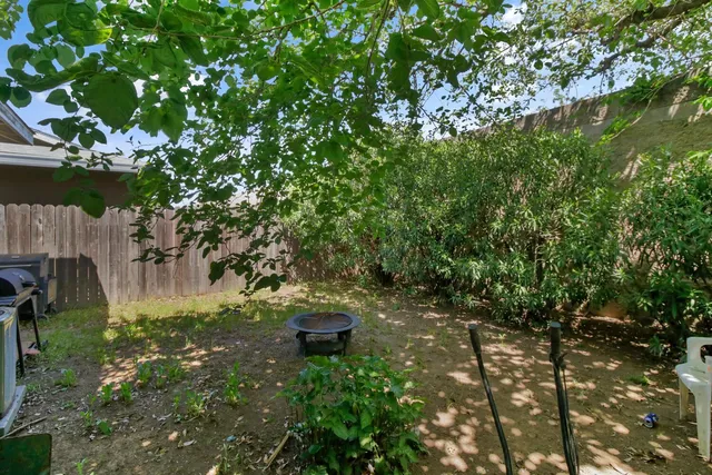 a backyard of a house with barbeque oven and outdoor seating