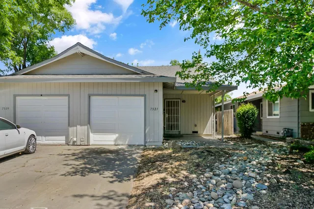 a view of a house with a small yard and wooden floor and fence