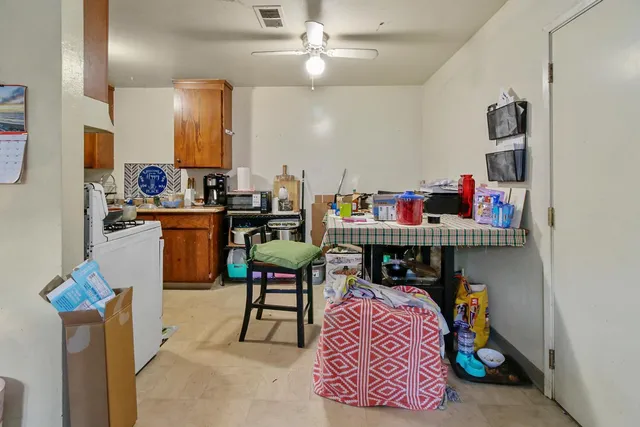 a kitchen with a refrigerator a stove a sink and a dining table with wooden floor