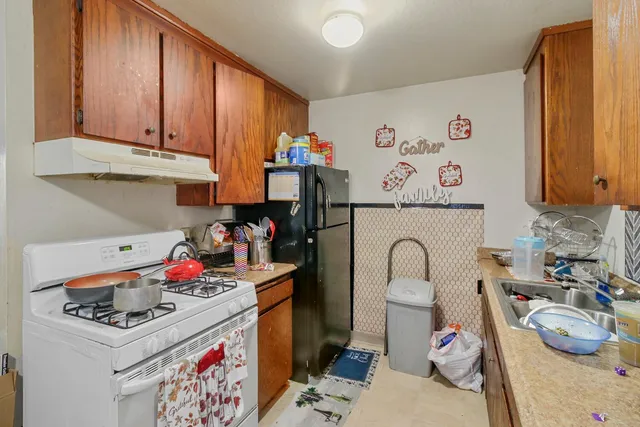 a kitchen that has a lot of cabinets a sink and a stove