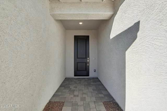 a view of a hallway with wooden floor and a bathroom