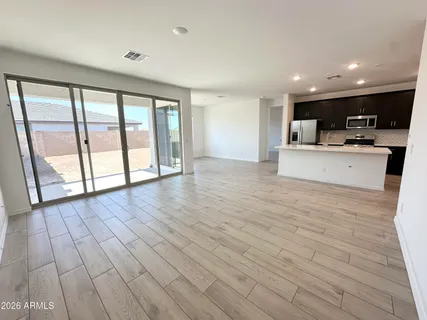 a view of a kitchen with kitchen island wooden floor and living room