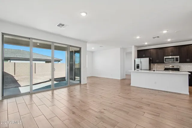 a kitchen with stainless steel appliances granite countertop a refrigerator stove top oven and sink