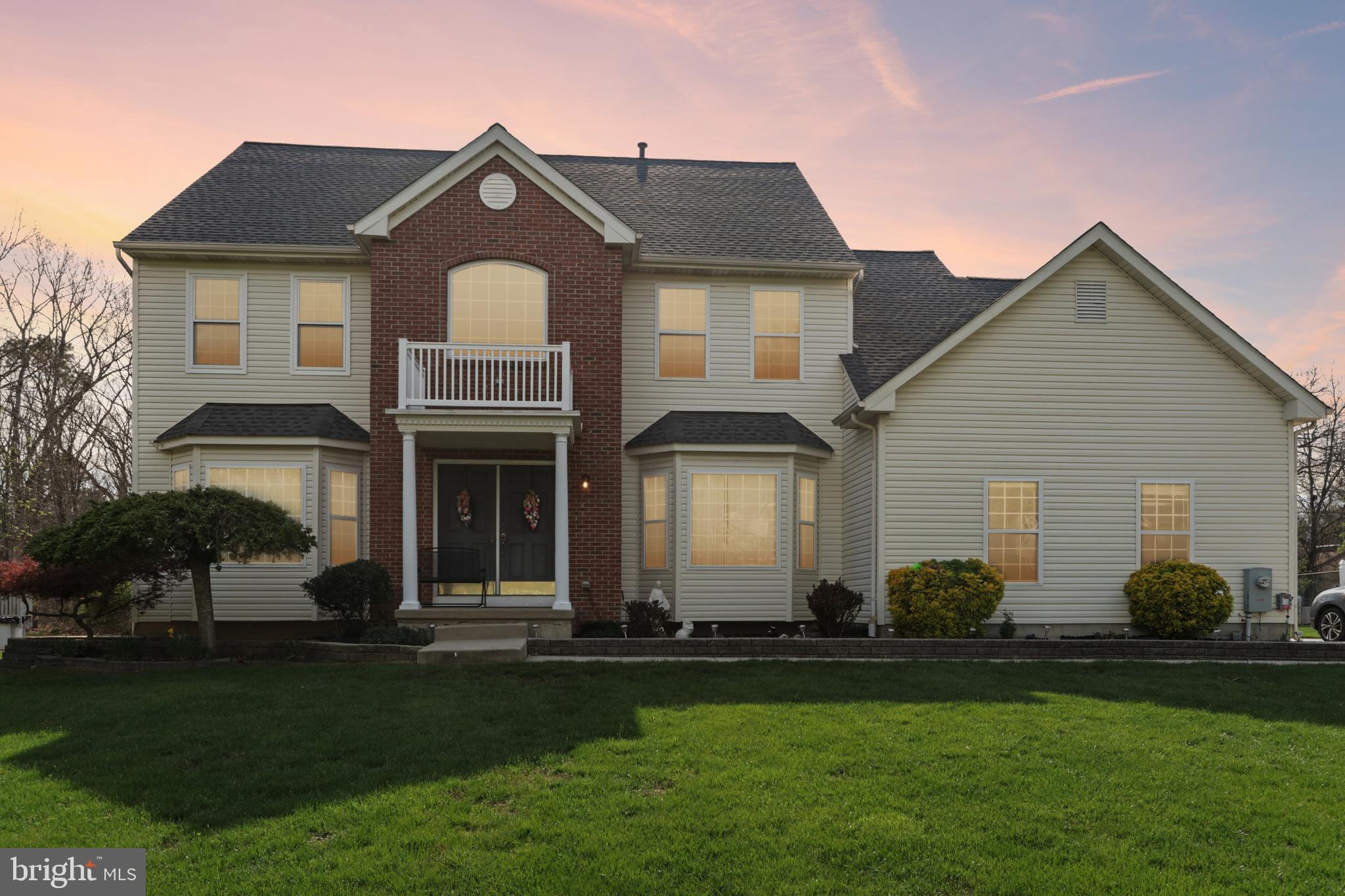 a front view of a house with a garden and plants