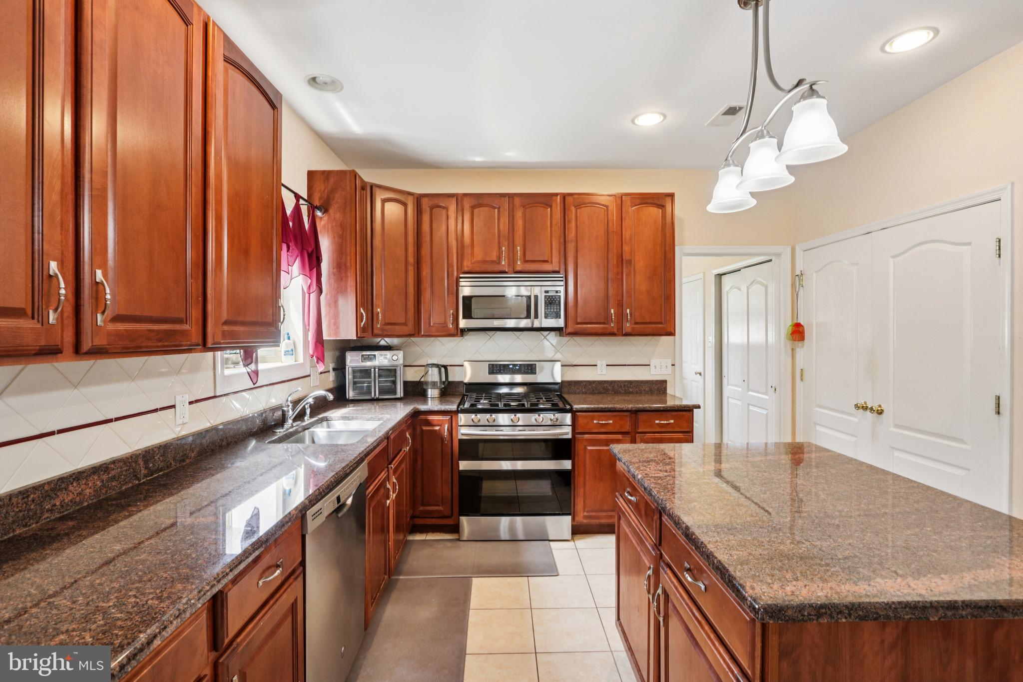 104 Ryans Run Sicklerville, NJ 08081 - Photo 25 of 94 a kitchen with stainless steel appliances granite countertop a stove a sink and a refrigerator