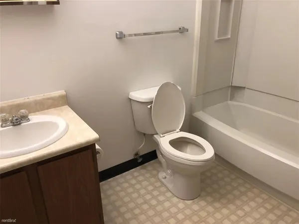 a white toilet sitting next to a bathroom sink and tub