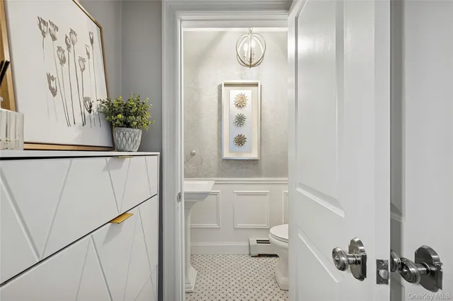a bathroom with a sink and mirror with toilet
