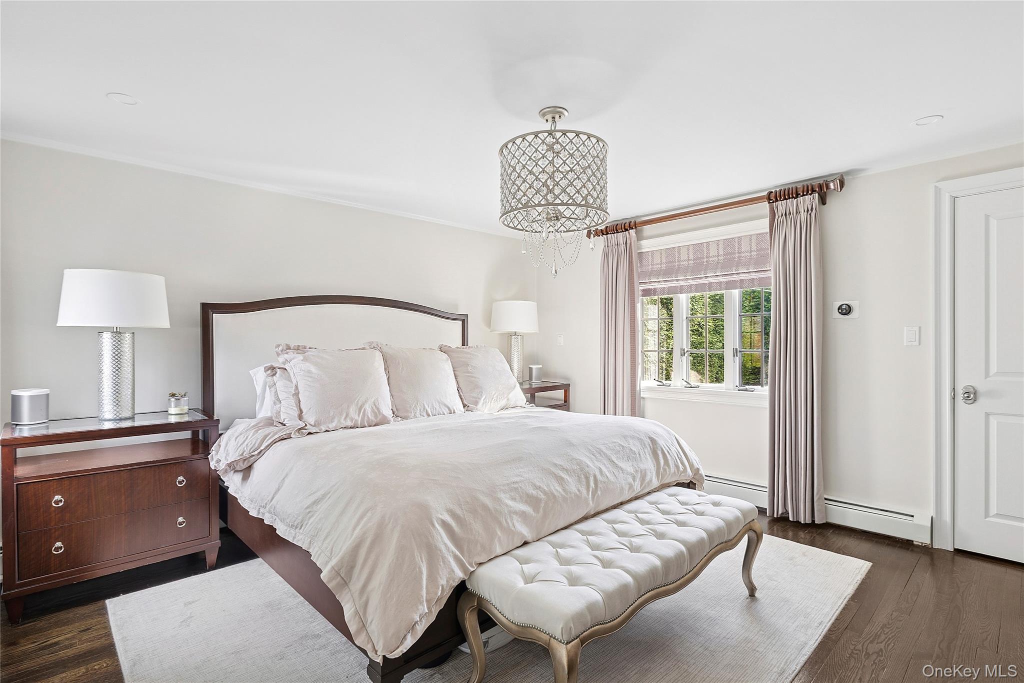 44 Old Ox Road Manhasset, NY 11030 - Photo 12 of 23 a bedroom with a bed and a chandelier