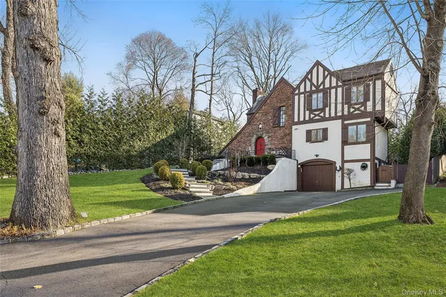 a view of a house with a yard patio and tree