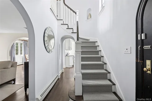 a view of staircase with wooden floor and white walls