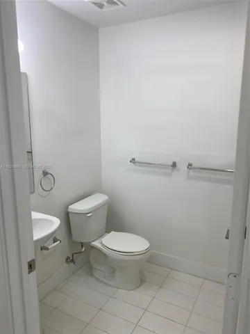 a white toilet sitting next to a shower