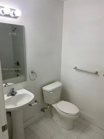 a bathroom with a toilet a sink and mirror