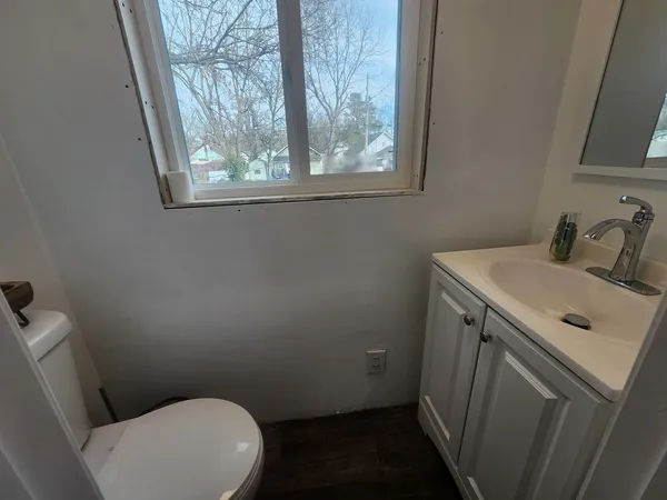 a bathroom with a sink toilet and window
