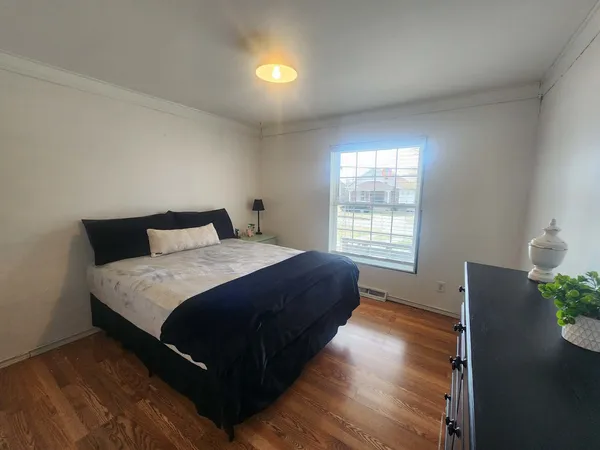 a bedroom with a bed and wooden floor