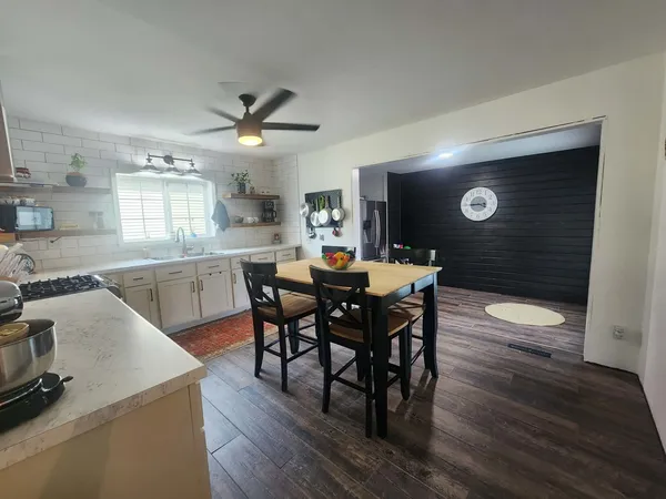 a kitchen with a dining table chairs and white cabinets