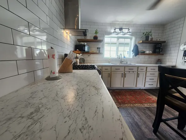 a kitchen with sink a stove and chairs
