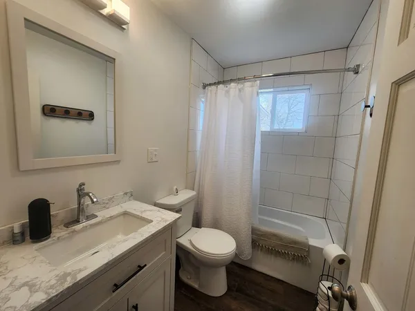 a bathroom with a granite countertop sink toilet and shower