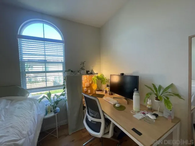 a view of a workspace with furniture and a window