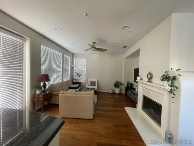 a living room with furniture a fireplace and wooden floor