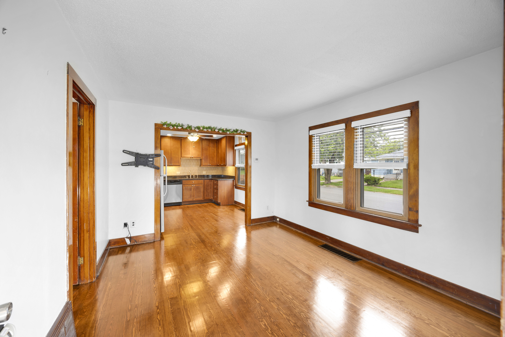 3403 Monroe Street Lansing, IL 60438 - Photo 2 of 10 a view of an empty room with a window and wooden floor